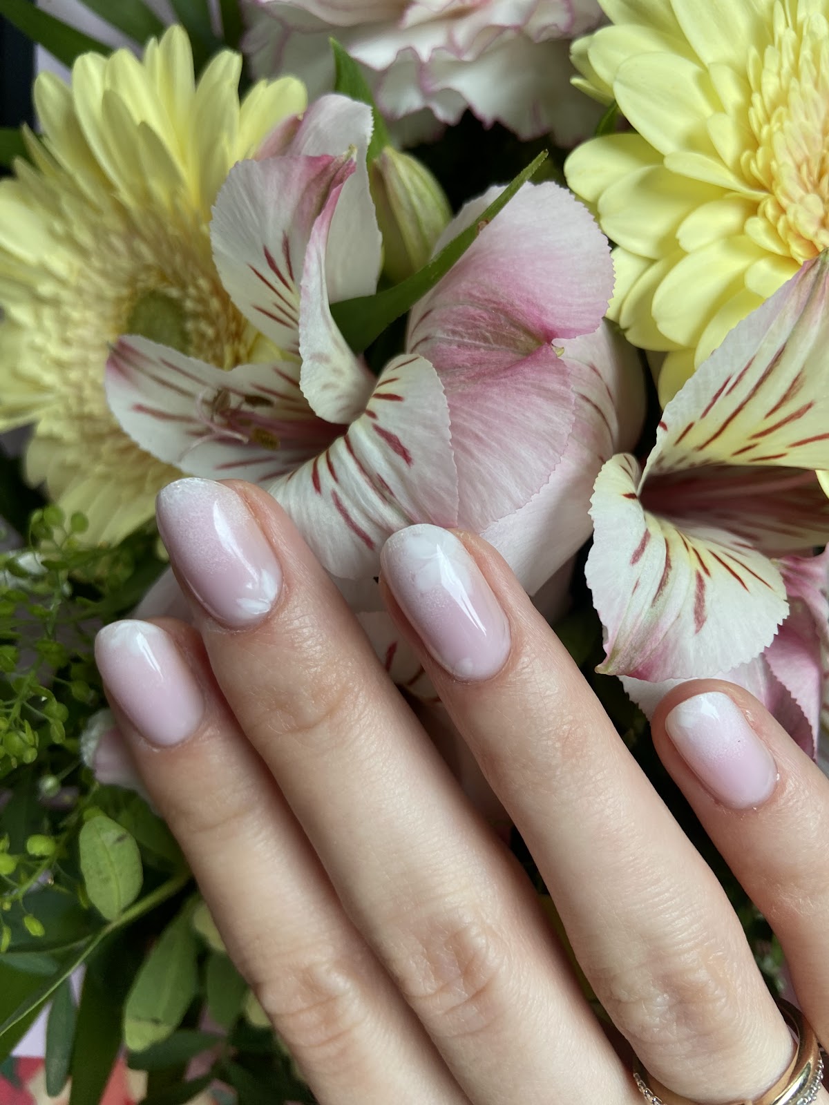 Pastelowy manicure ombre na tle bukietu kwiatów